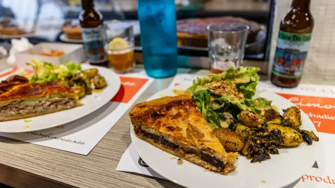 Tranche de pâté en croûte, spécialité Limoges, servie avec salade et pommes de terre rôties.
