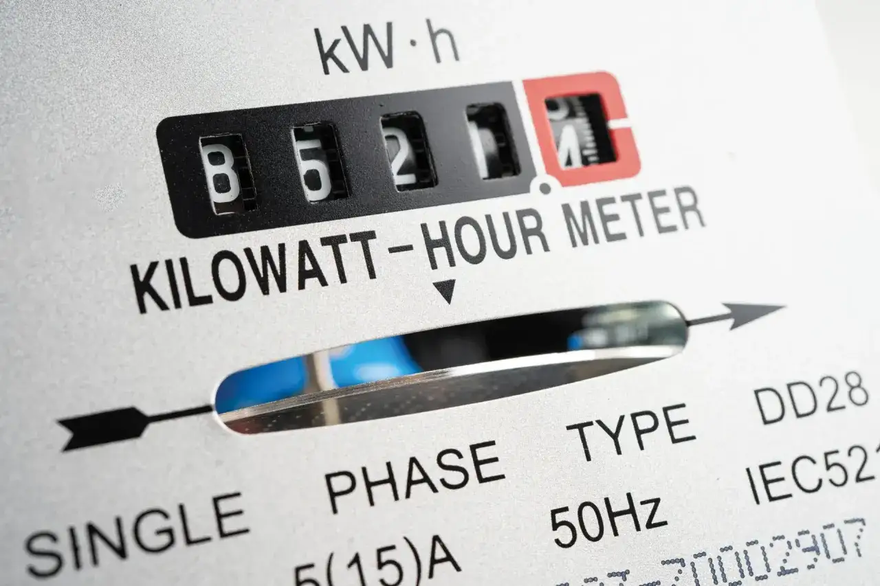 Zbliżenie licznika energii elektrycznej. Widoczne cyfry 85211, oznaczenie KILOWATT-HOUR METER. Wartość ta może wpływać na opłatę mocową.