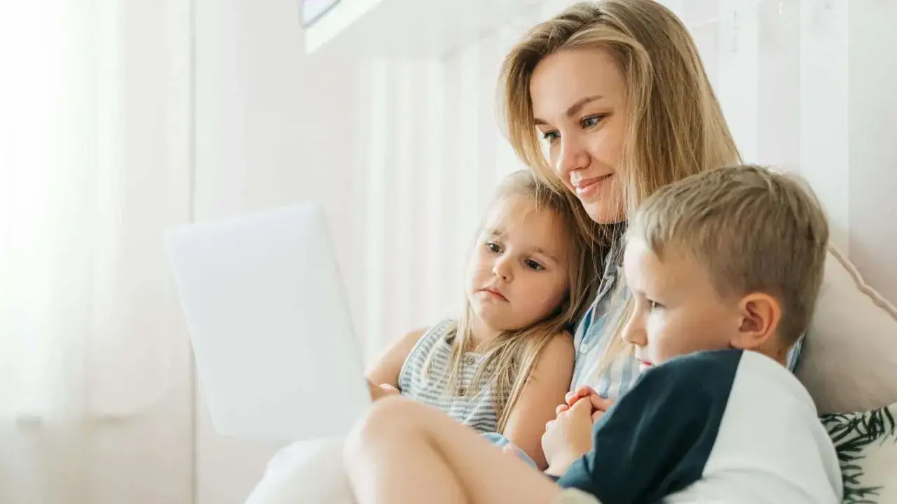 Mama z dwójką dzieci ogląda coś na laptopie. Czy dziecko może zdecydować z którym rodzicem chce mieszkać?