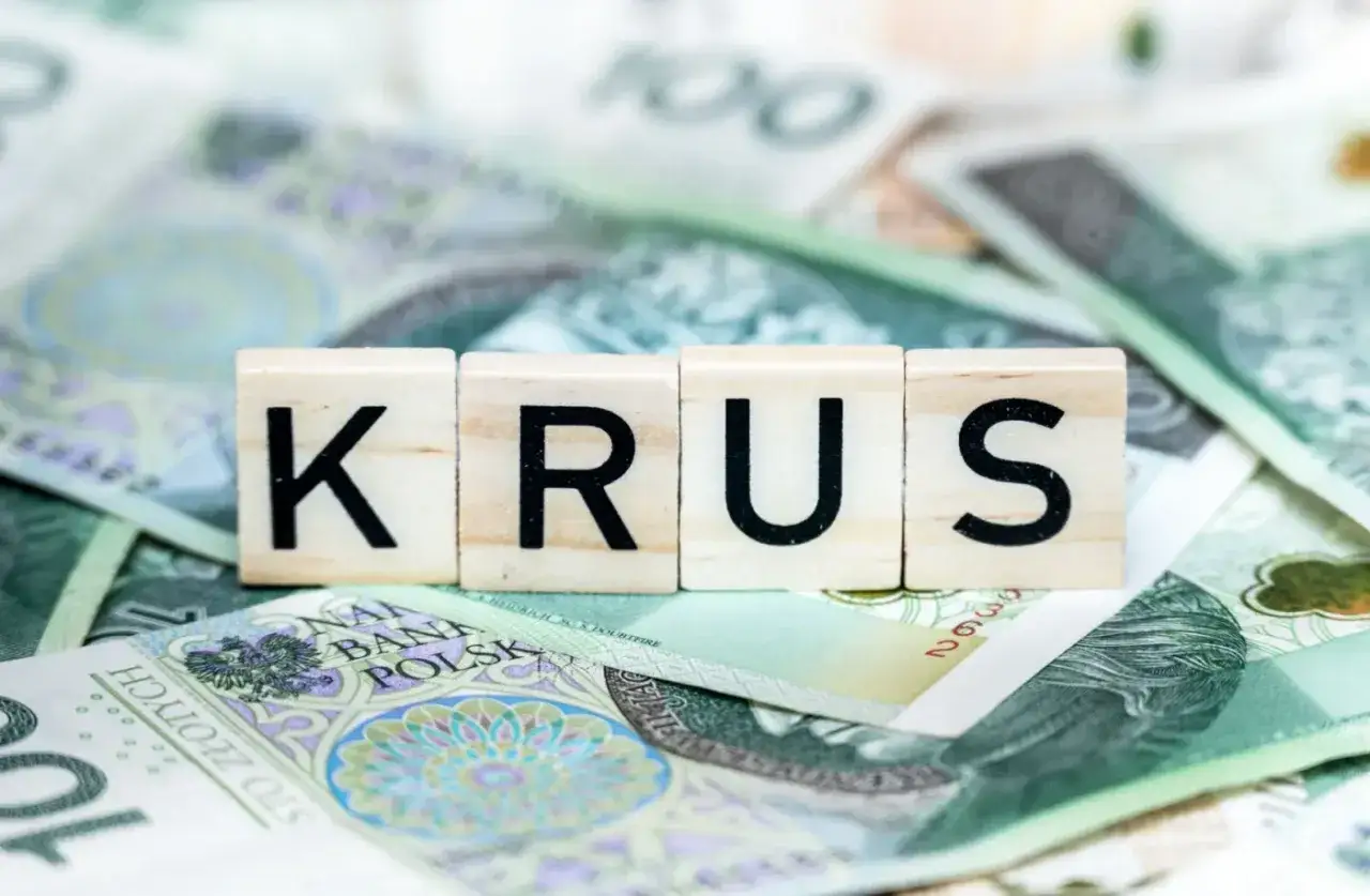 Litery K, R, U, S na tle polskich banknotów. Symbolizują dodatki do renty z tytułu całkowitej niezdolności do pracy.