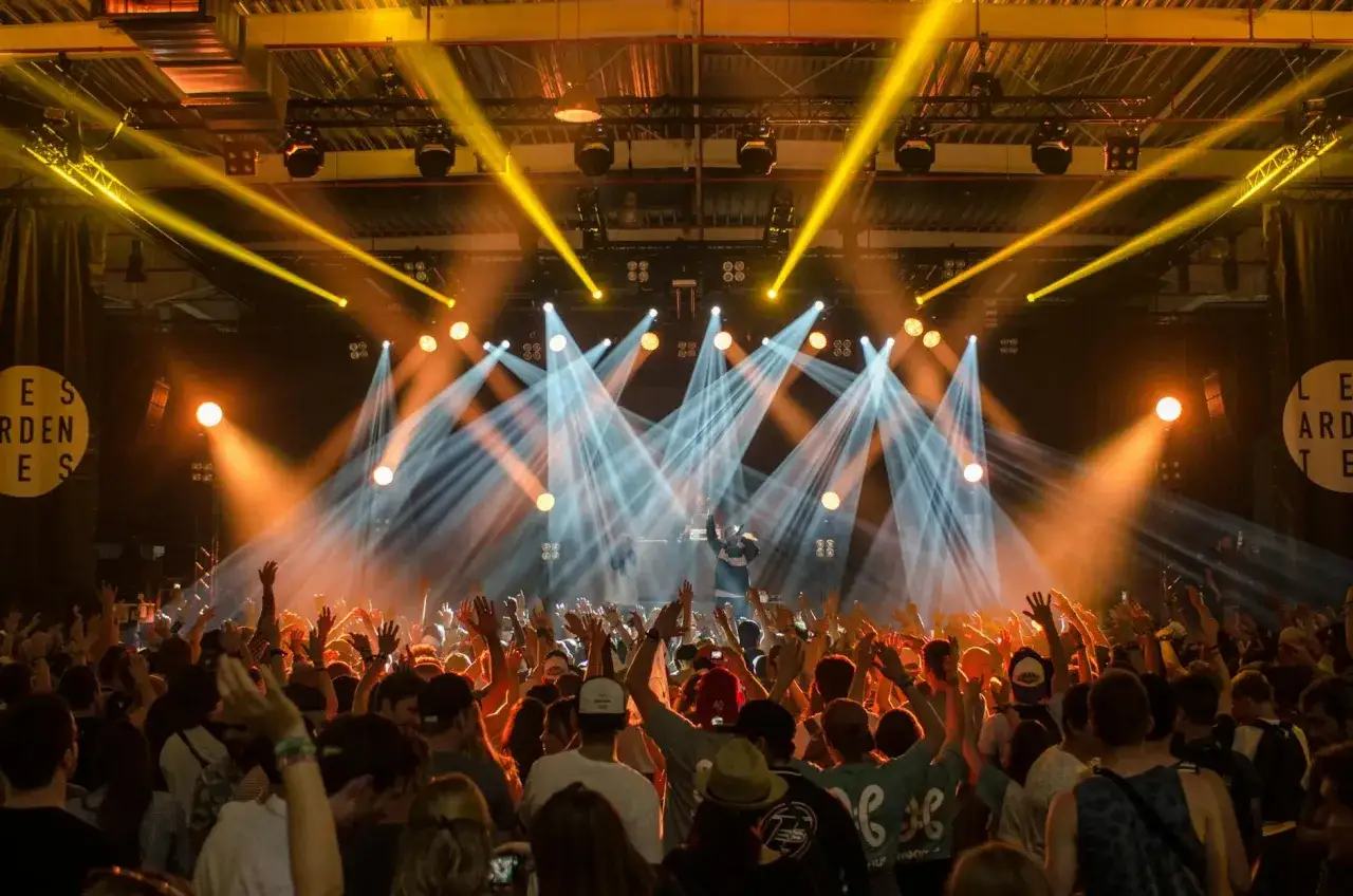 Tłumy na festiwalu muzycznym szaleją pod światłami sceny.