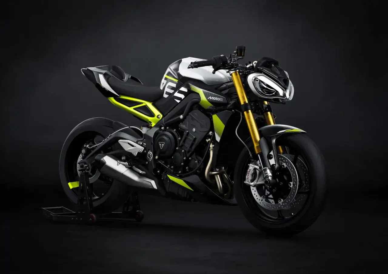 Nowoczesny motocykl Triumph Street Triple w białym i czarnym malowaniu z neonowo-żółtymi akcentami, gotowy do drogi.