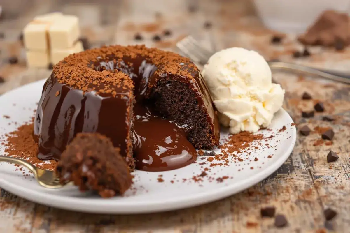 Gâteau au chocolat coulant, illustrant la différence entre moelleux et fondant. Servi avec une boule de glace à la vanille.