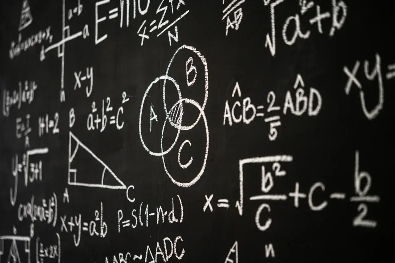 Tablica z matematycznymi wzorami i diagramami, w tym diagramem Venna.