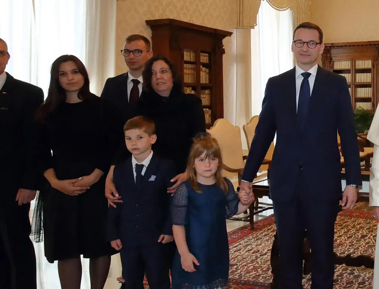 Mateusz Morawiecki z rodziną, w tym z dziećmi w różnym wieku, podczas oficjalnego spotkania.