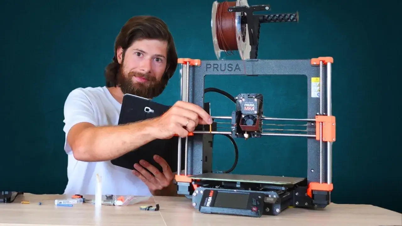 Mężczyzna z tabletem przy drukarce 3D Prusa MK4.