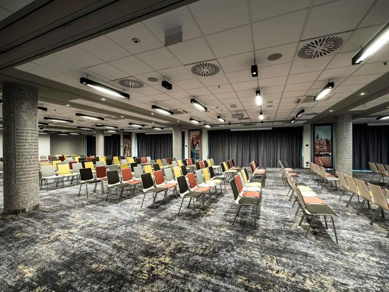 Sala konferencyjna w hotelu Mercure Wrocław, przygotowana na wydarzenie. Rzędy kolorowych krzeseł czekają na gości.