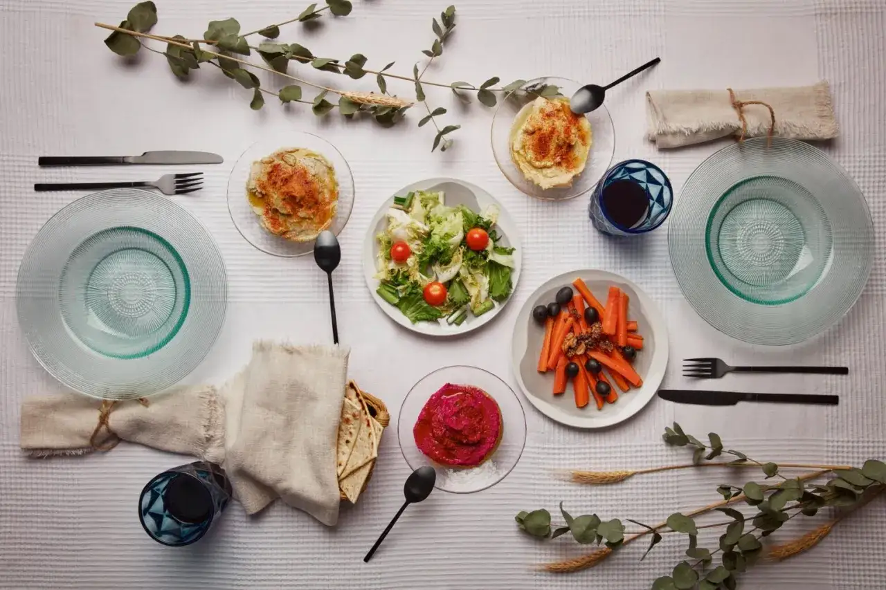 Un repas végétarien servi à l'assiette : houmous, salade, carottes et betterave. Une belle définition du service à l'assiette.