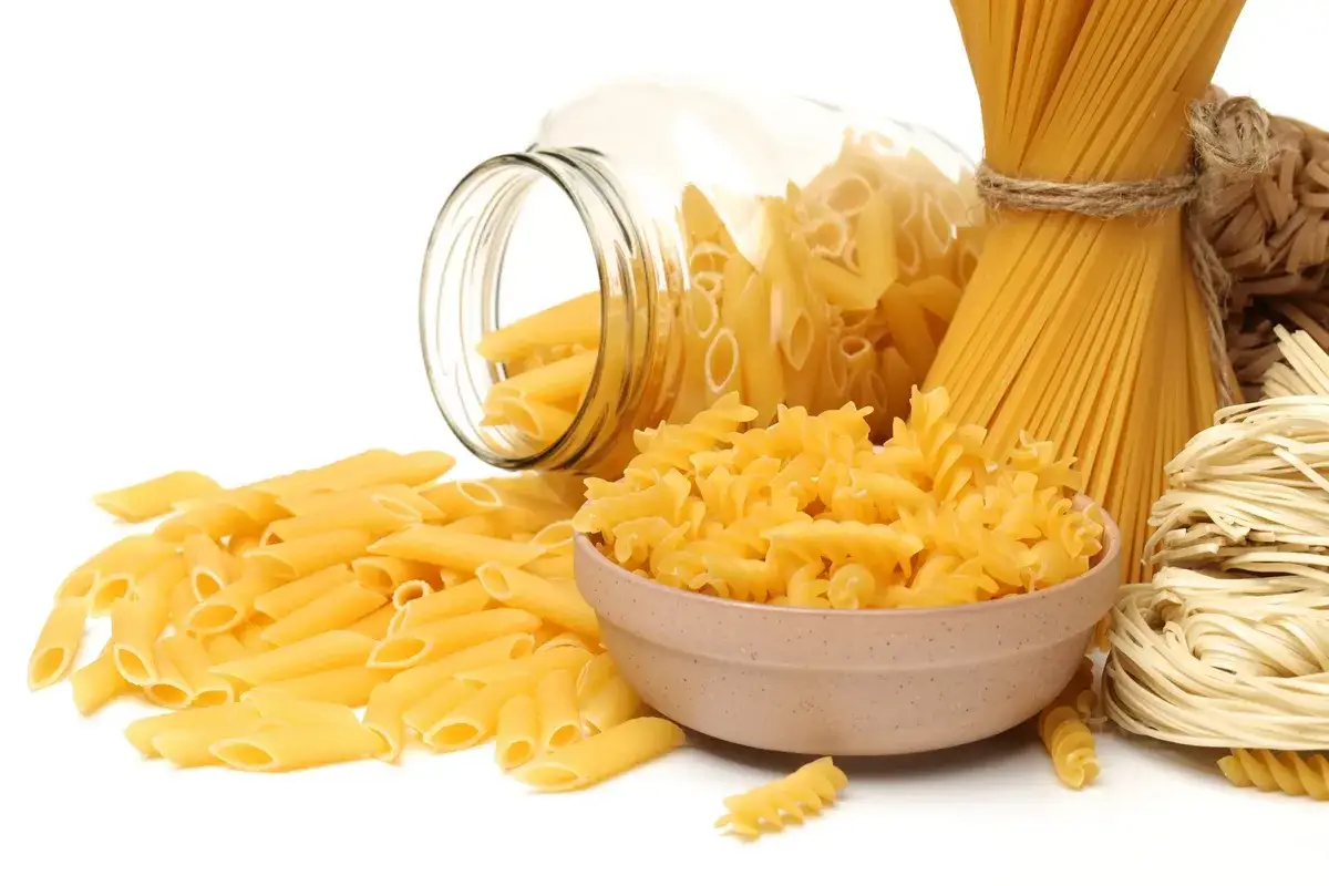 Różne rodzaje makaronu: penne, fusilli w miseczce, spaghetti nr 5 i spaghettini.
