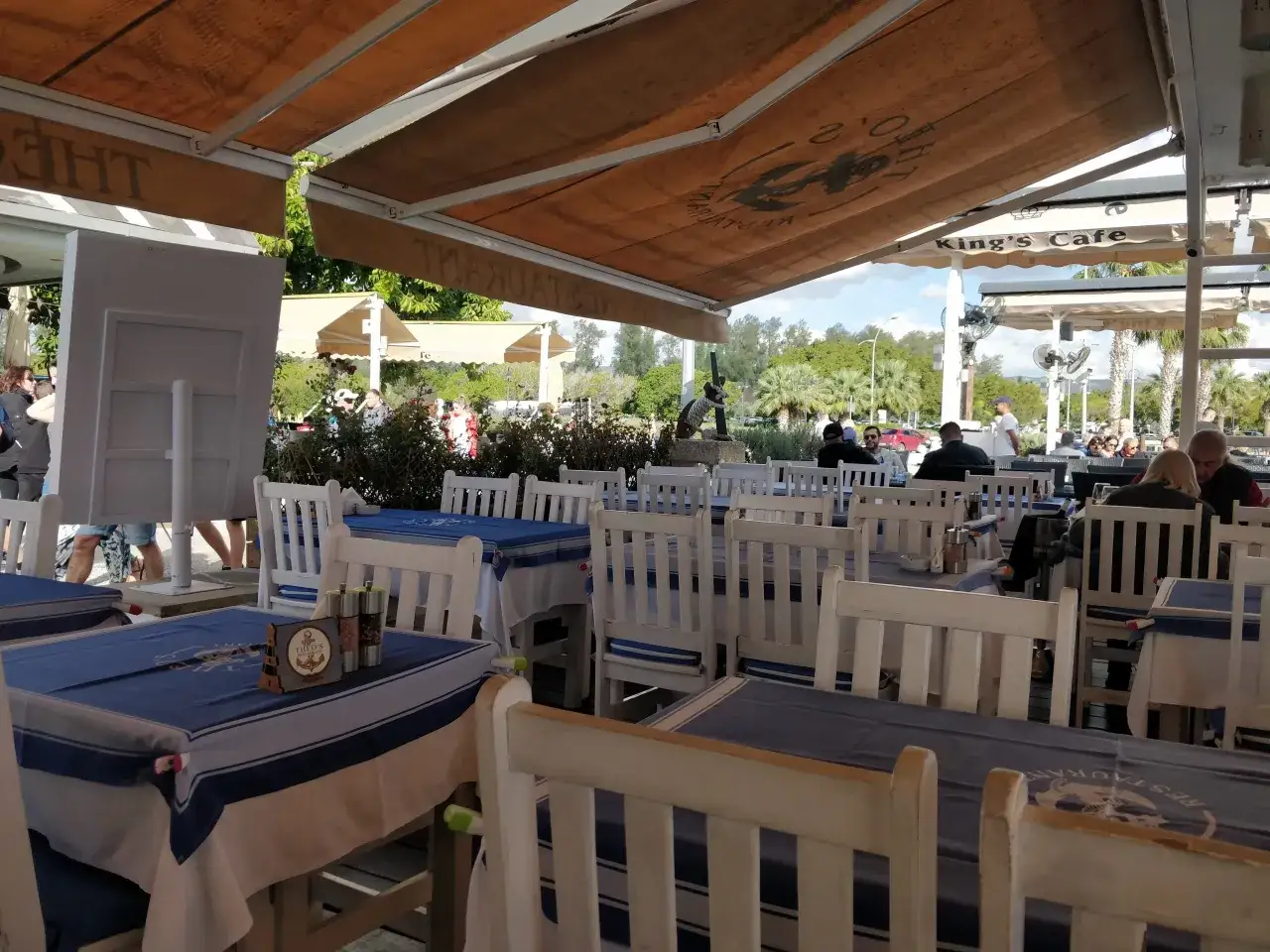 Uroczy ogródek restauracyjny w Larnace z niebiesko-białymi obrusami. Idealne miejsce, by dowiedzieć się, co i gdzie zjeść w Larnace.