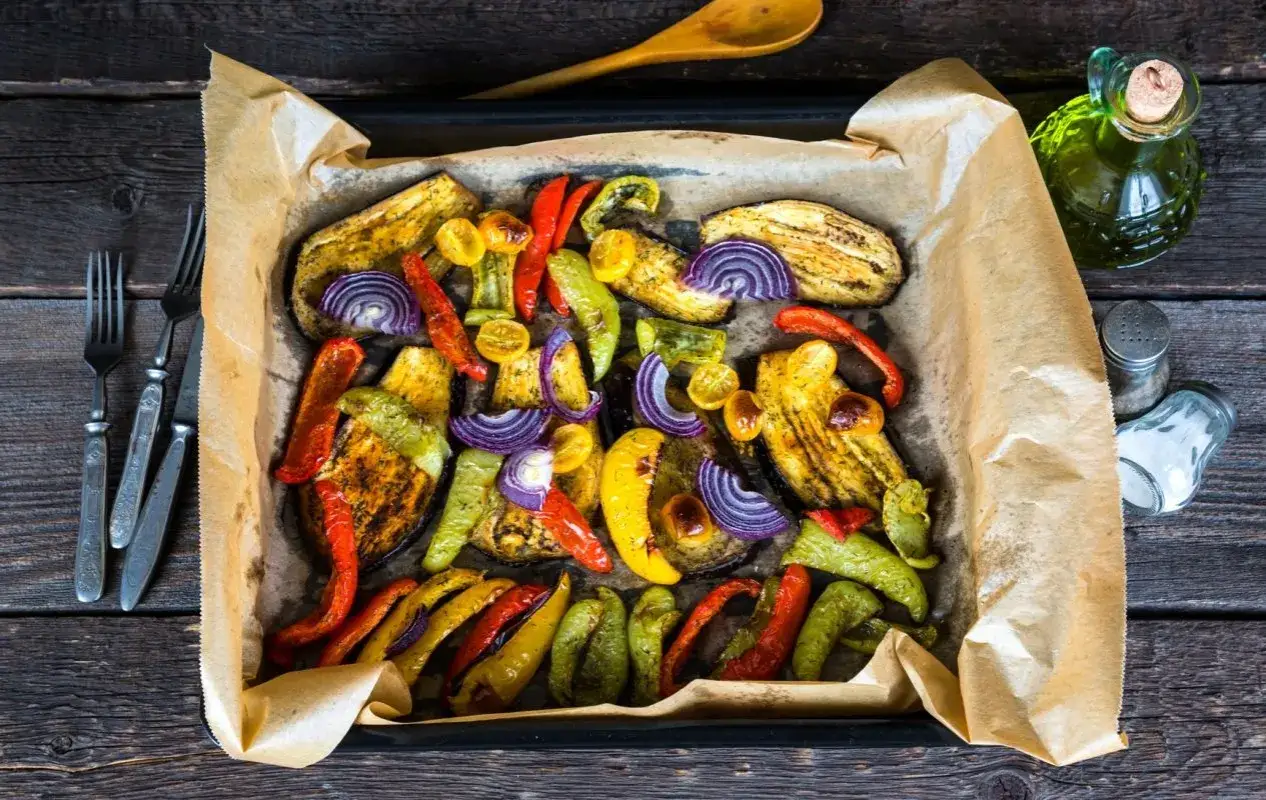 Kolorowe warzywa pieczone w piekarniku: bakłażan, papryka, cebula i pomidorki.