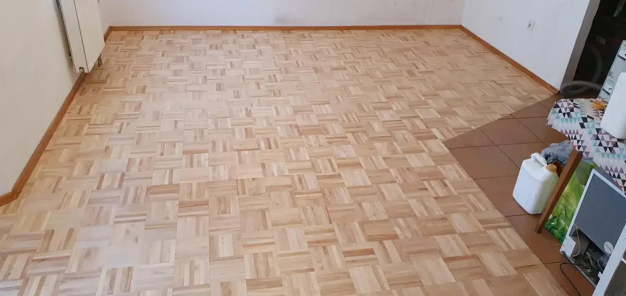 Odnowiony parkiet w jodełkę. Zastanawiasz się, ile kosztuje cyklinowanie parkietu? Ten piękny, drewniany wzór czeka na renowację.