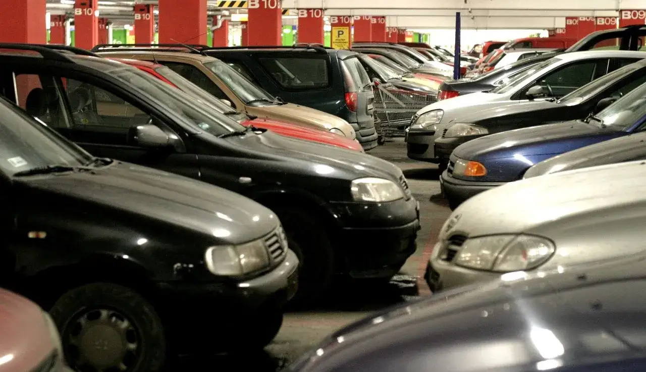 Rzędy samochodów na parkingu podziemnym. Widać oznaczenia B10, które mogą sugerować wymiary miejsca parkingowego.