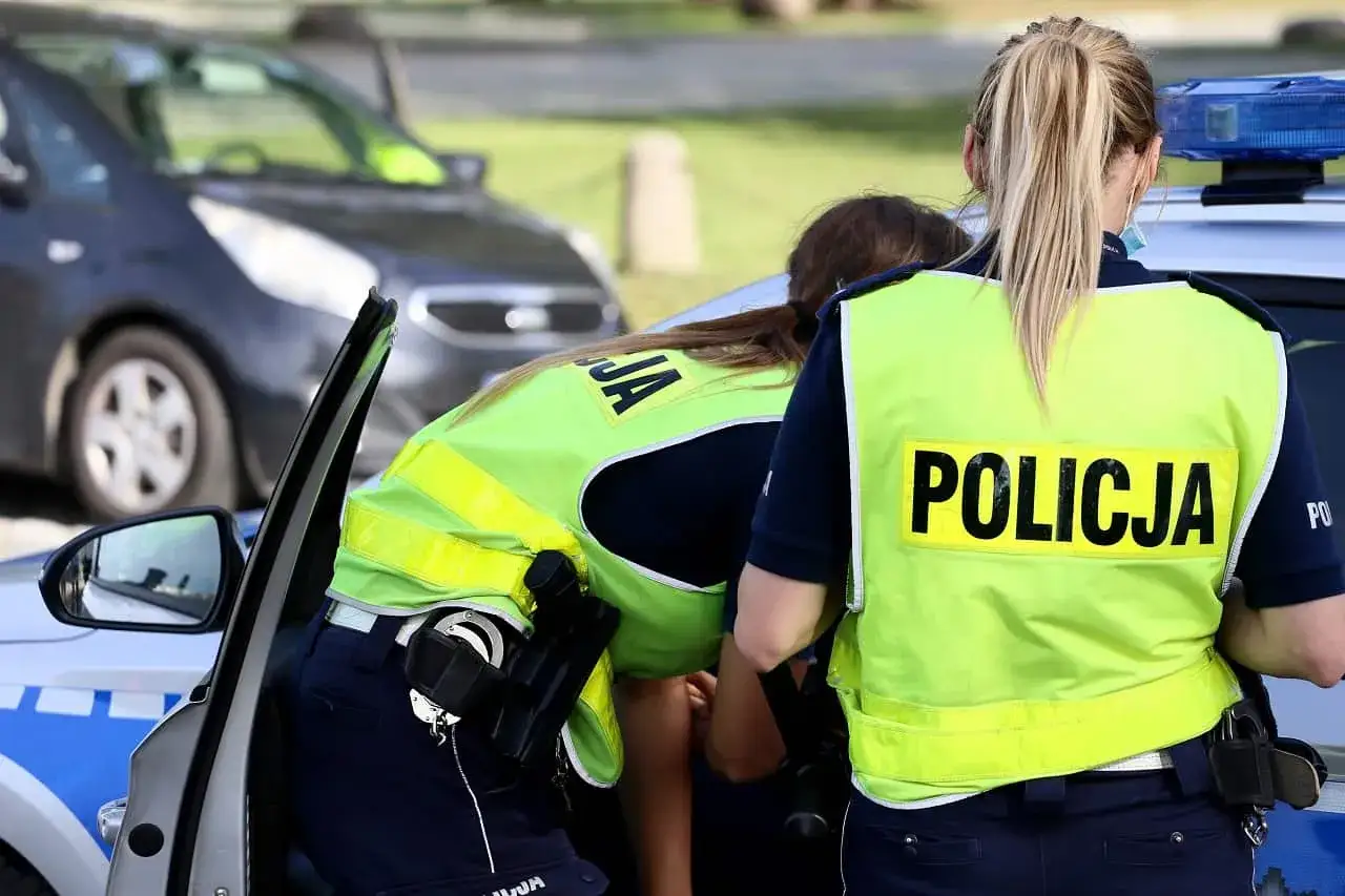 Policjantki w kamizelkach odblaskowych przy radiowozie. Czy trzeba mieć przy sobie OC? To pytanie zadaje sobie wielu kierowców.