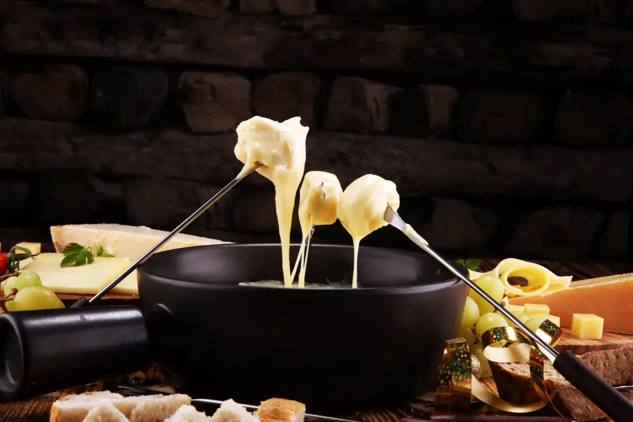 Fondue au fromage, une des spécialités culinaires parisiennes, servie avec du pain et des raisins.