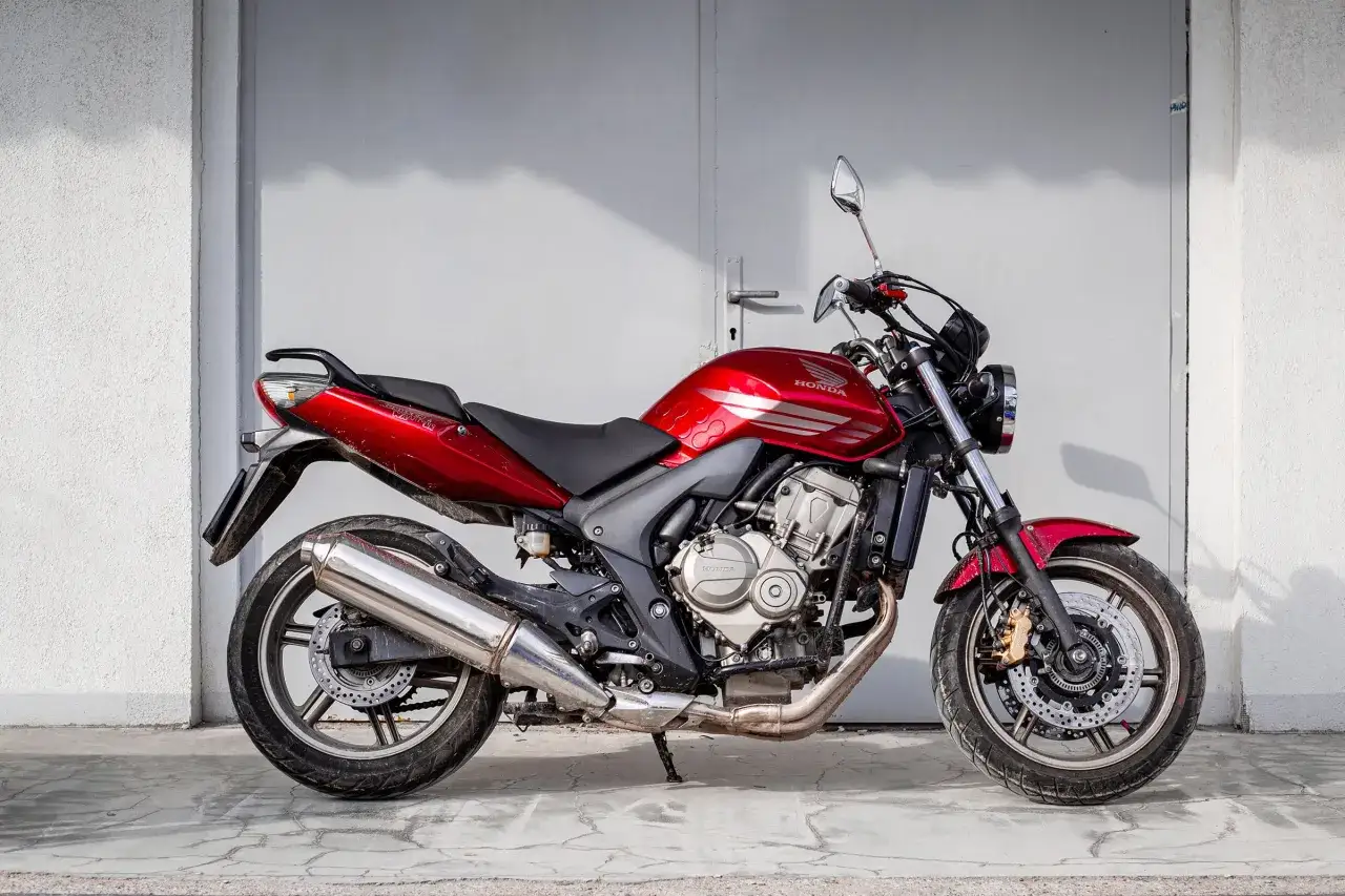 Czerwony motorower Honda Hornet, idealny do miasta. Zastanawiasz się, ile kosztuje motorower tej klasy?