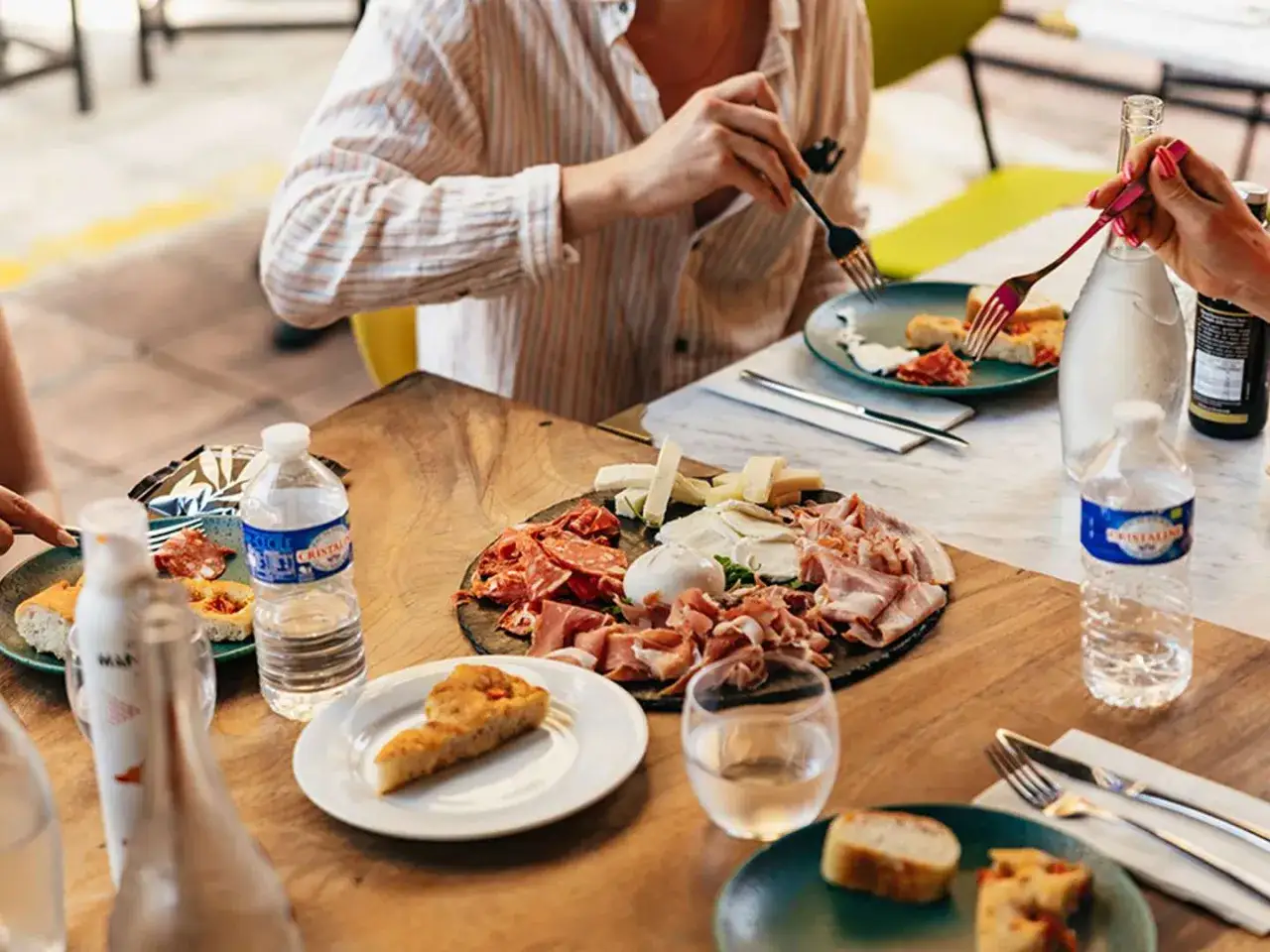 Un plateau de charcuterie et fromages, une spécialité provençale, partagé autour d'une table ensoleillée.
