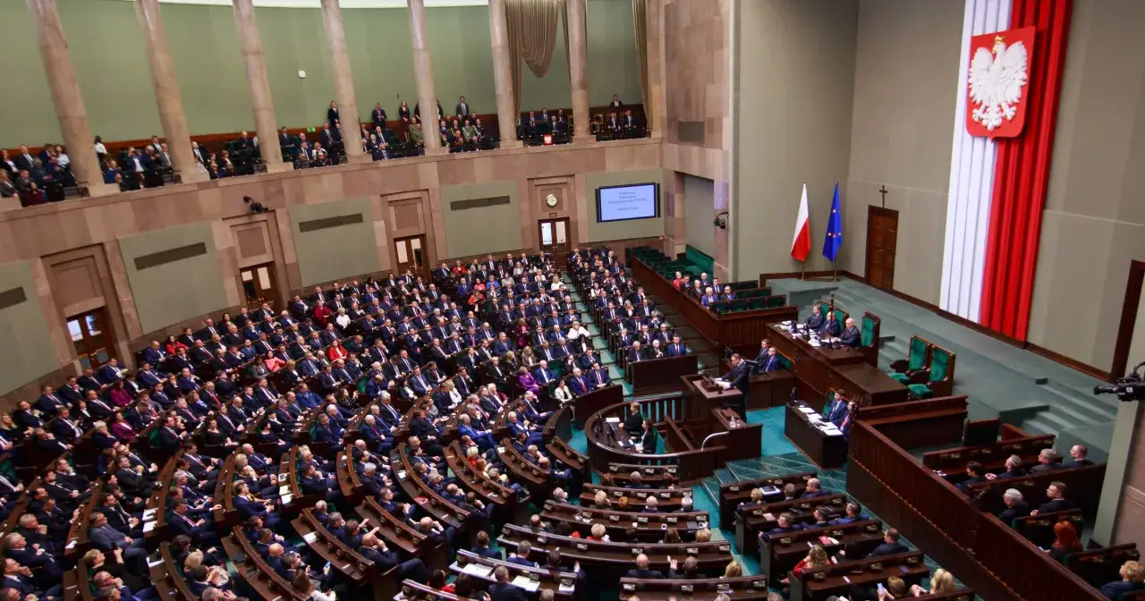 Widok na salę plenarną Sejmu RP z posłami siedzącymi w ławach.