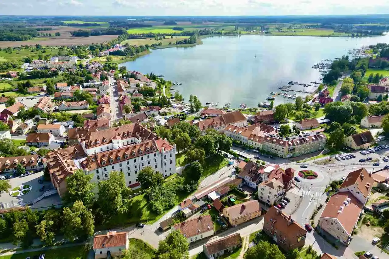 Widok z lotu ptaka na miasteczko nad jeziorem z zamkiem i mariną.