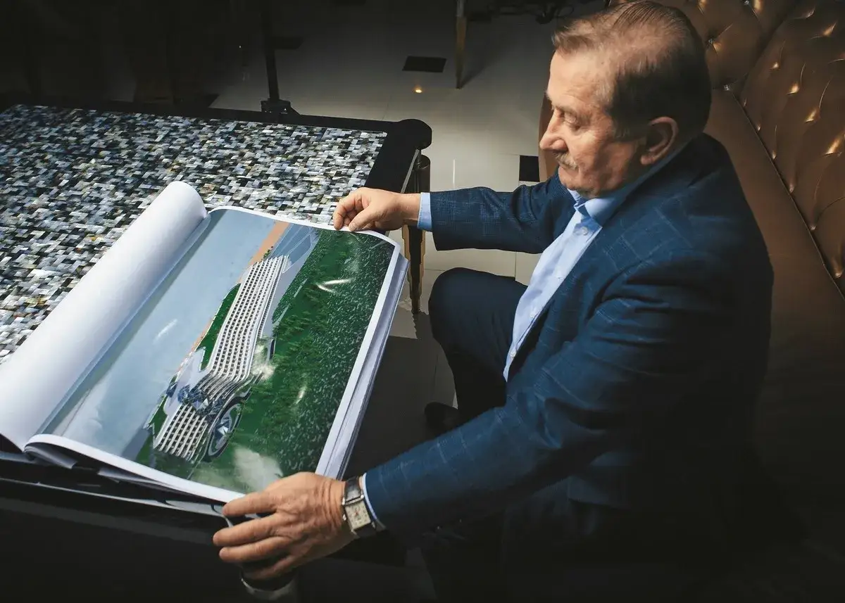 Henryk Gołębiewski, właściciel hoteli, ogląda projekt nowoczesnego hotelu zlokalizowanego nad wodą.