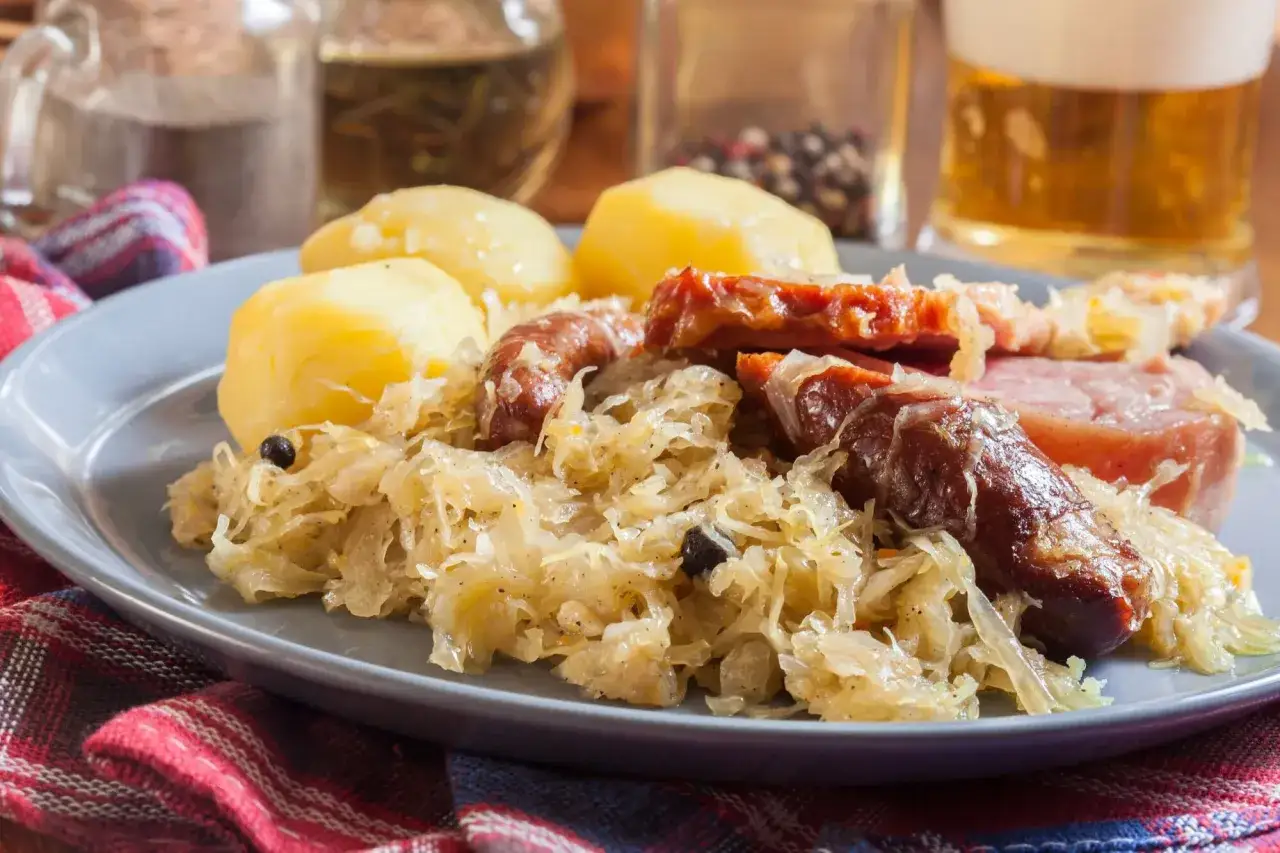Assiette de choucroute garnie avec pommes de terre, saucisses et lard. Un plat typique de restaurant.