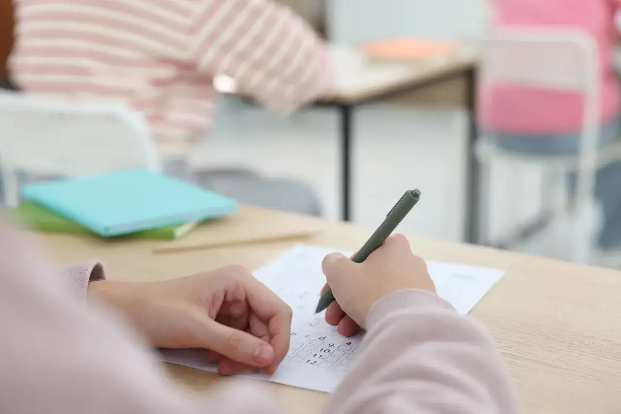 Uczeń pisze test, zastanawiając się, ile jest punktów na maturze z matematyki.