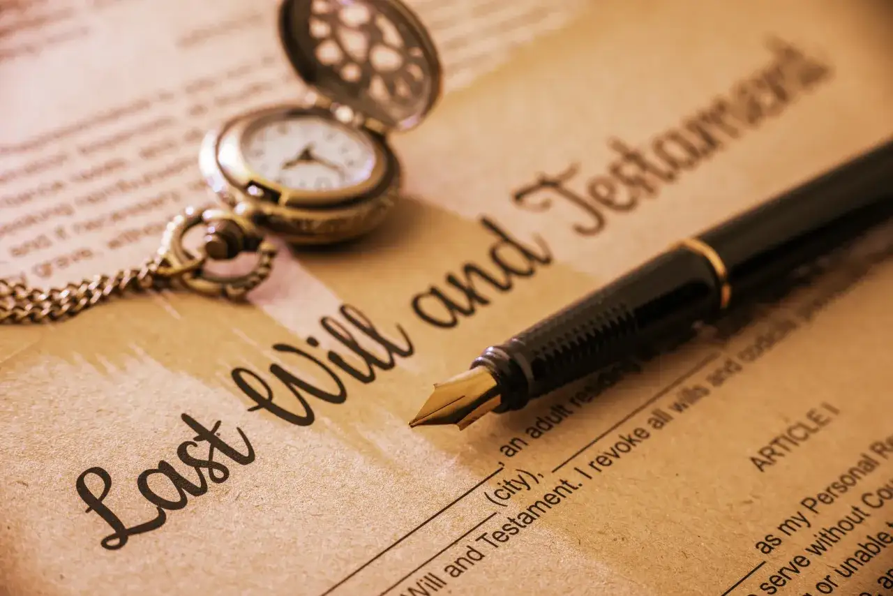 Otwarta kieszonkowa zegarek i pióro na dokumencie "Last Will and Testament".