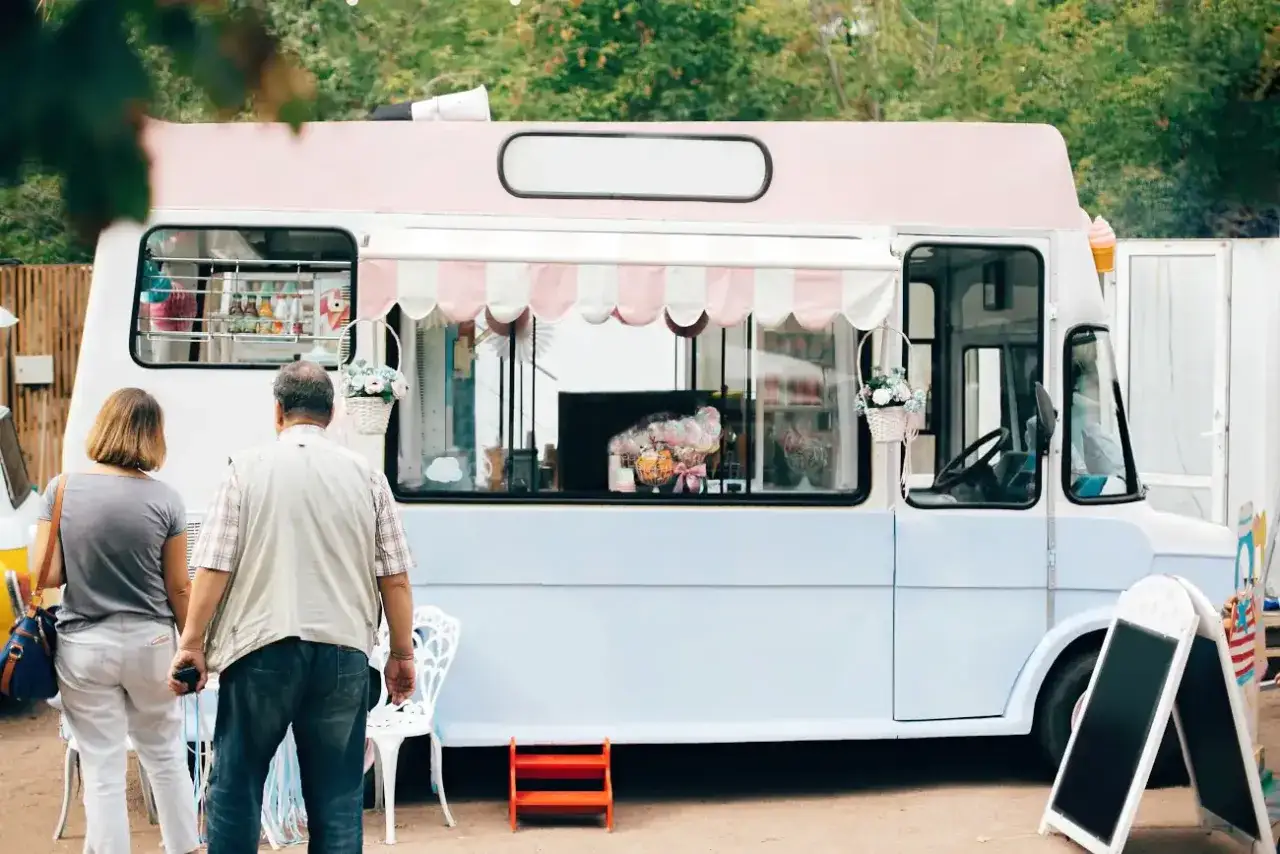 Para food trucków i handlu obwoźnego: jakie są wymogi sanepidu? Uroczy food truck z lodami, para klientów.