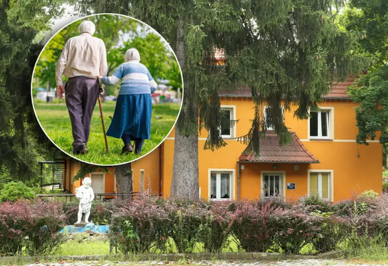 Spacer po parku przy sanatorium w Przerzeczynie Zdroju. Starsza para, wspierając się laską, cieszy się spokojnym popołudniem.