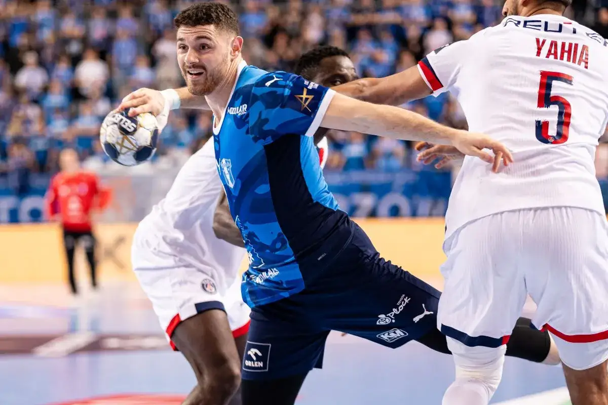 Piłkarz Wisły Płock w akcji przeciwko PSG. Zawodnik w niebieskiej koszulce z piłką w ręku, gotowy do rzutu.