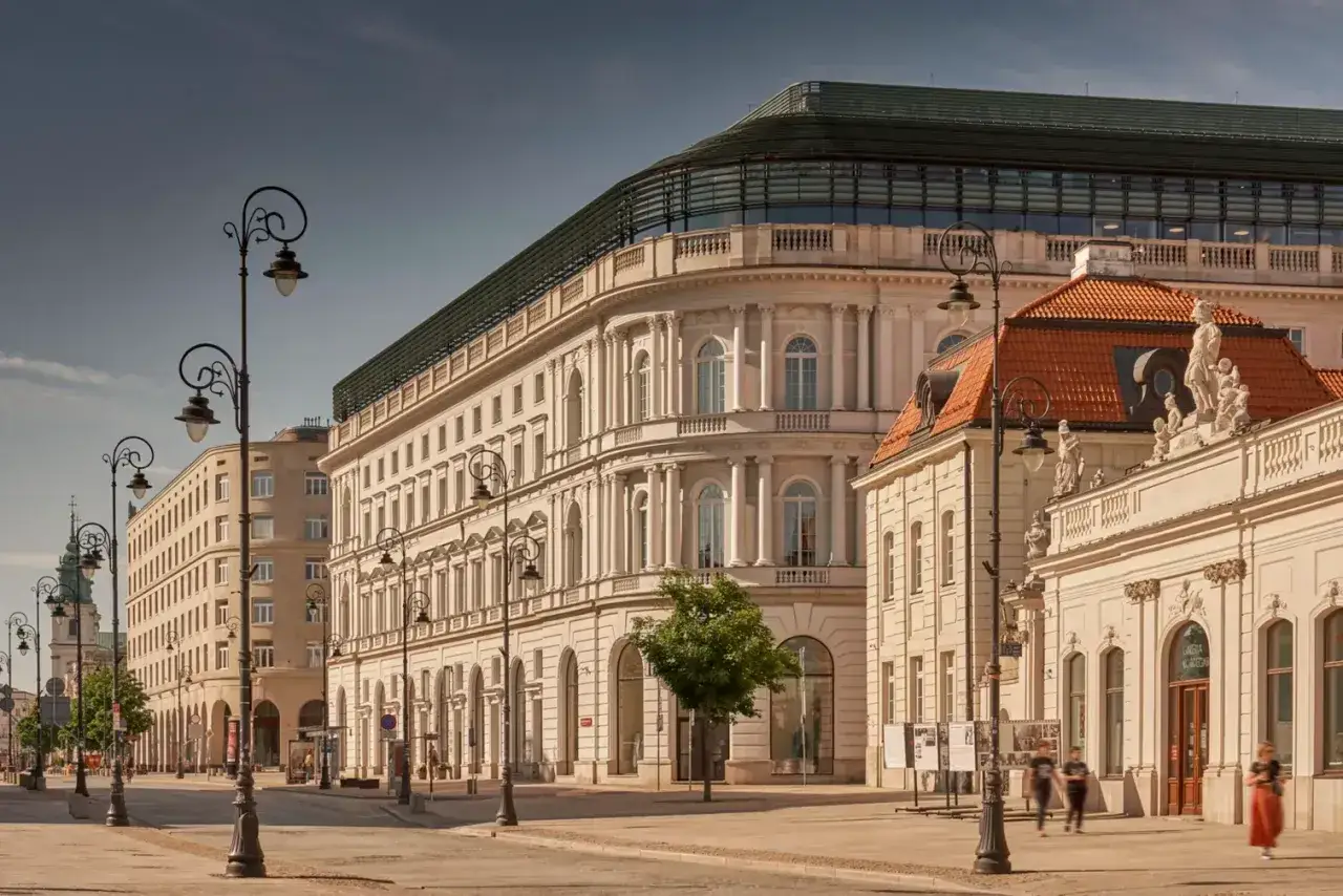 Elegancka kamienica z nowoczesnym dachem, być może najdroższy hotel w Polsce, przy słonecznej ulicy z zabytkowymi latarniami.