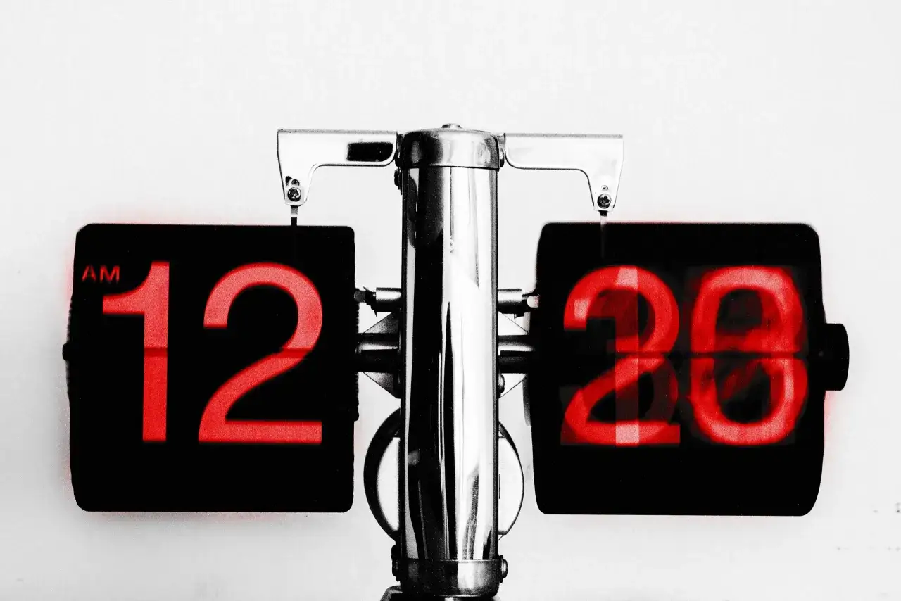 Stary zegar z czerwoną tarczą pokazuje 12:20. Jak legalnie udowodnić kradzież czasu pracy przez pracownika?