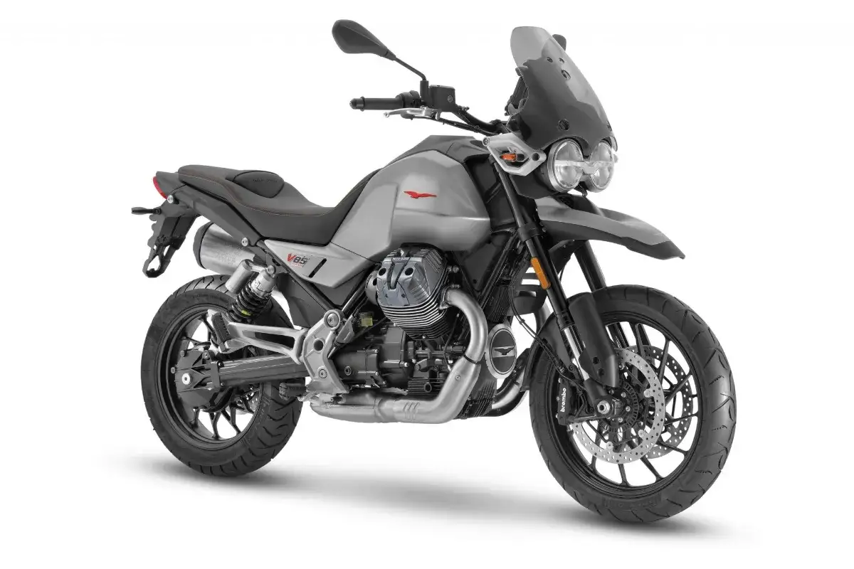 Srebrny motocykl Moto Guzzi V85 TT z charakterystycznym silnikiem V-twin, gotowy na przygodę.