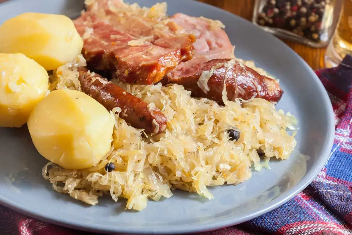 Assiette de spécialités alsace : choucroute garnie avec pommes de terre, saucisses et viande fumée.
