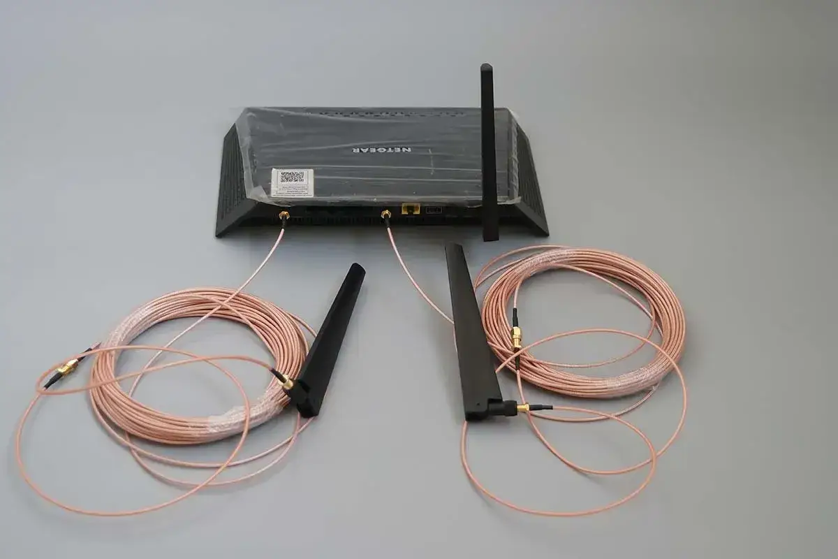 Router z dwoma kablami i antenami. Zastanawiasz się, czy można przedłużyć kabel antenowy? Tak, zestawy jak ten pozwalają na to.