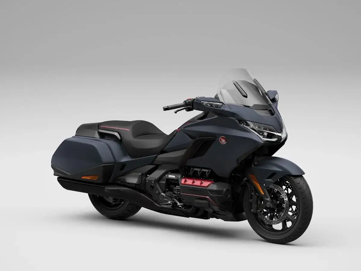 Ciemnoszary motocykl Honda Gold Wing z czarnym siedzeniem i kuframi, gotowy na dalekie podróże.