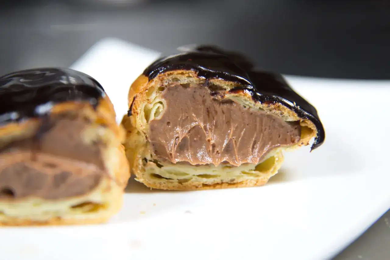 Éclairs généreusement garnis de crème pâtissière chocolat, nappés d'un glaçage brillant. Un délice gourmand.