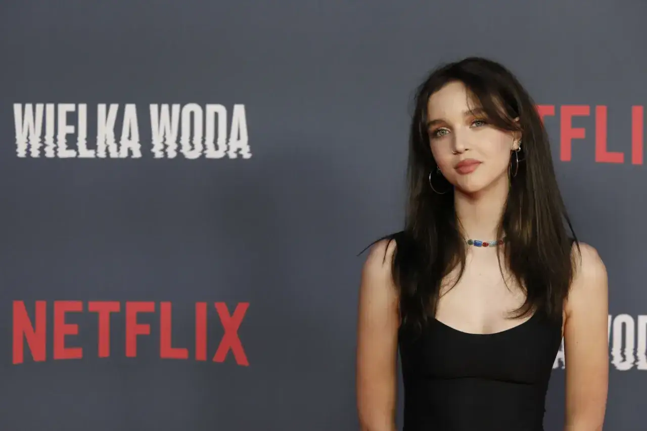 Młoda kobieta na tle napisu "WIELKA WODA" i logo Netflix. Wygląda jakby miała zaraz wskoczyć do wielkiej wody, niczym kot.