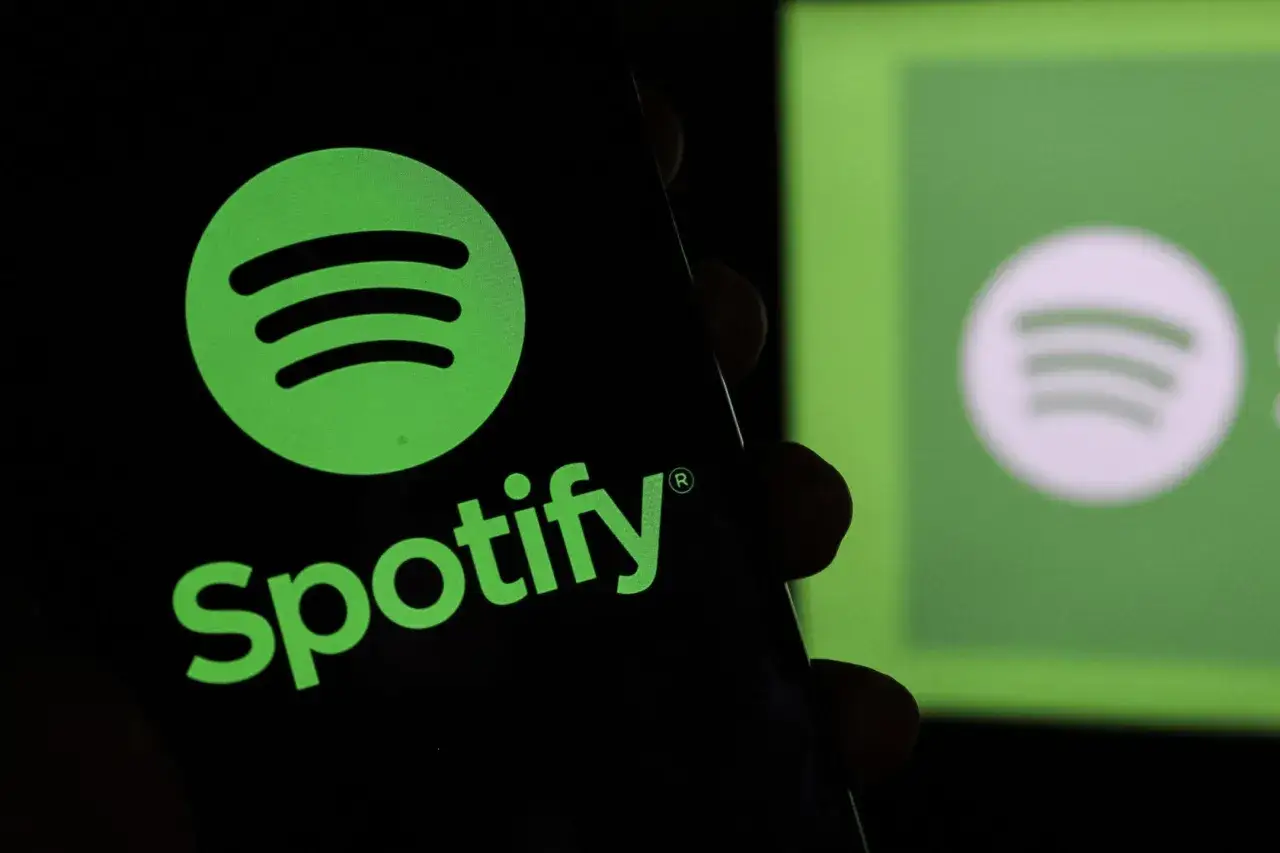 Logo Spotify na czarnym tle, z rozmytym logo na zielonym tle w tle.