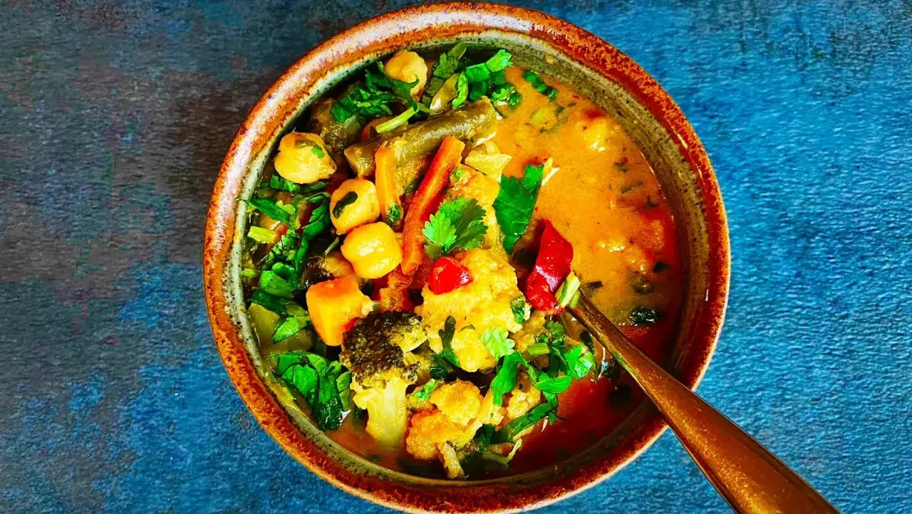 Miseczka tajskiego curry z warzywami, ciecierzycą i mlekiem kokosowym.