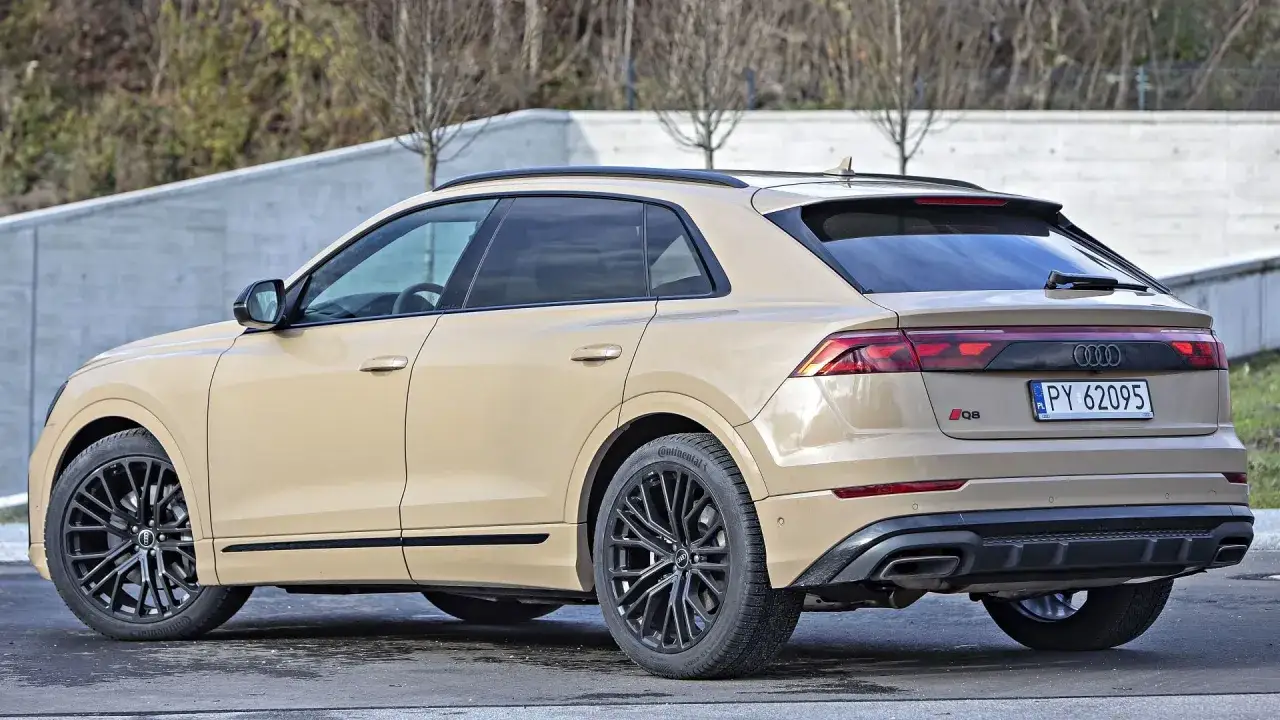 Beżowe Audi RSQ8 z czarnymi felgami stoi na zewnątrz.