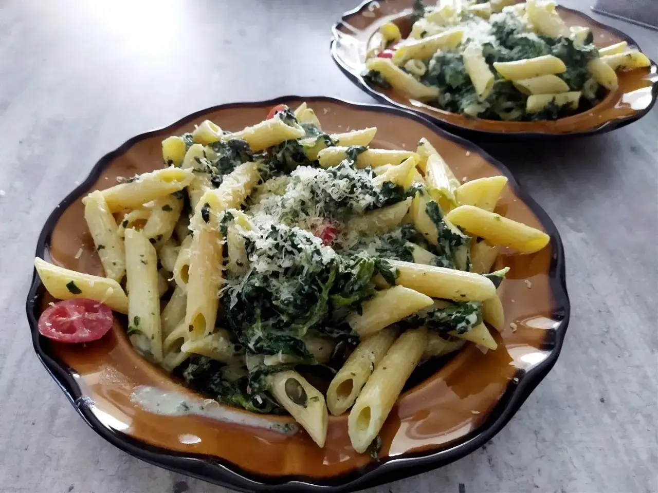 Penne z fetą i szpinakiem, posypane parmezanem. Idealny przepis na makaron ze szpinakiem i fetą.