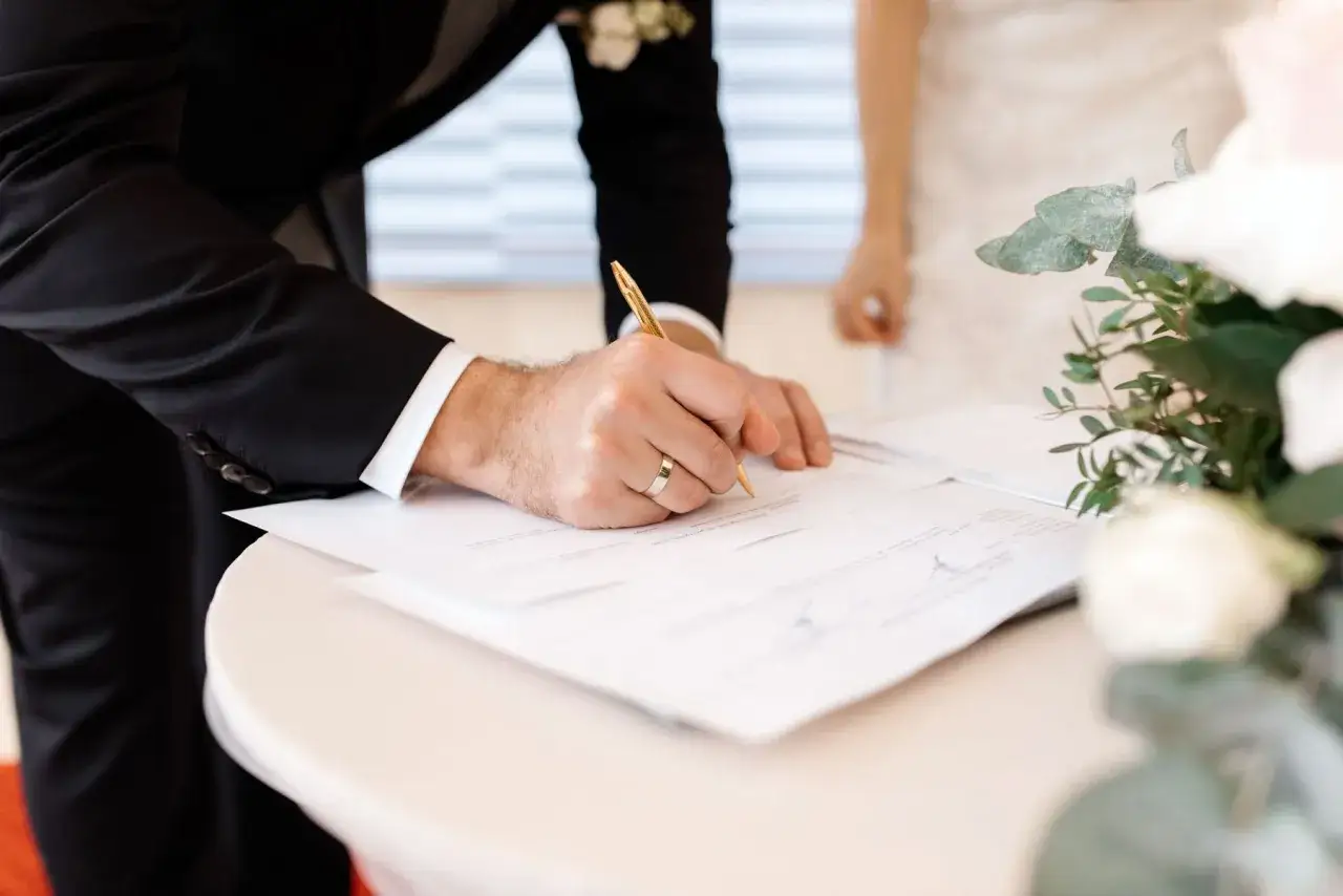 Novio firma documentos. Esto es parte de lo que se necesita para casarse por lo civil.