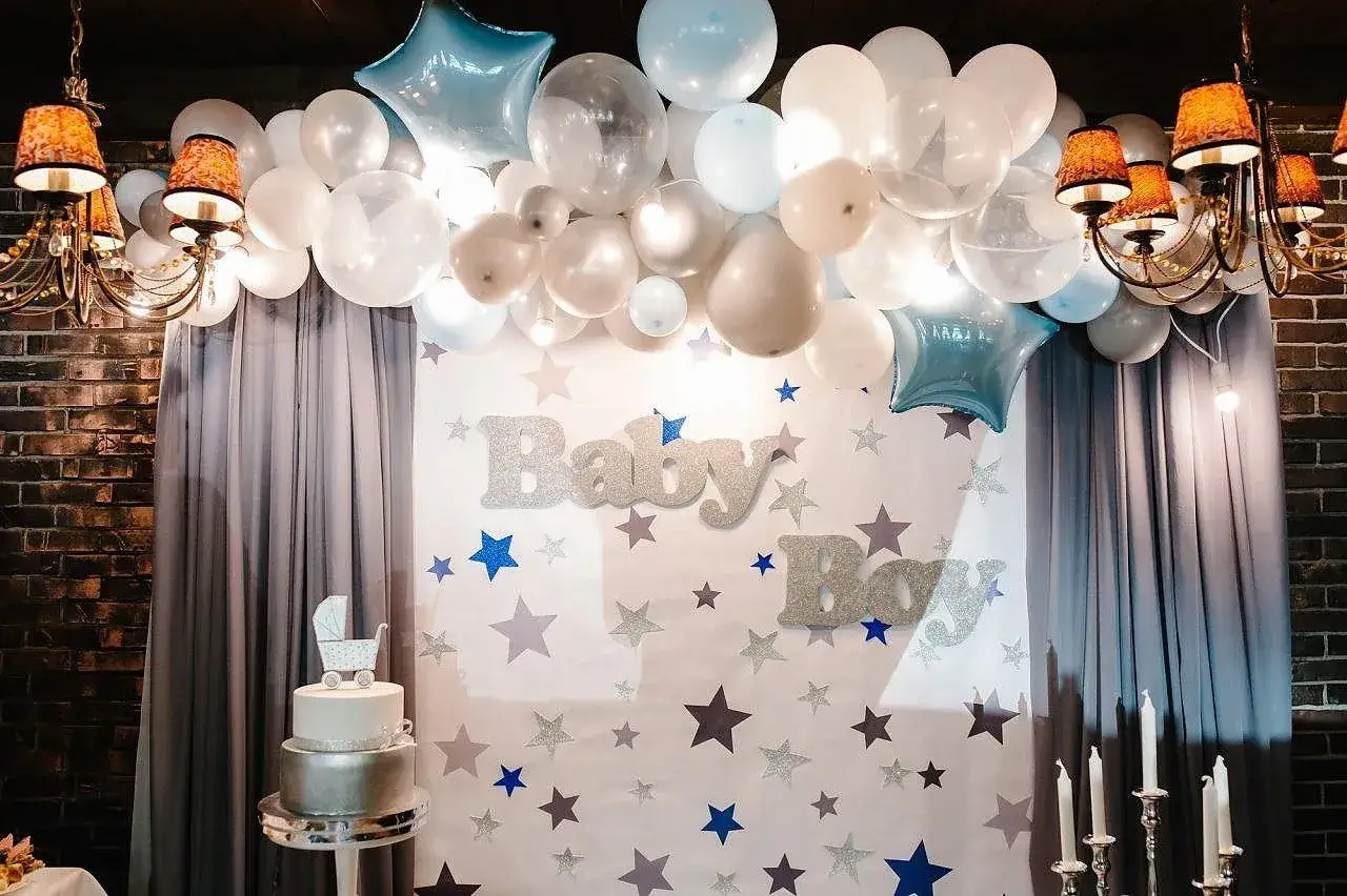 Dekoracja na chrzest święty: balony, gwiazdki, tort i napisy "Baby Boy".