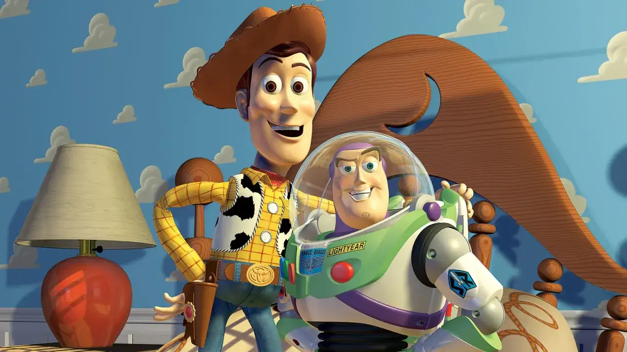 Woody i Buzz Lightyear, bohaterowie bajek z dzieciństwa, pozują na tle niebieskiej ściany z chmurkami.