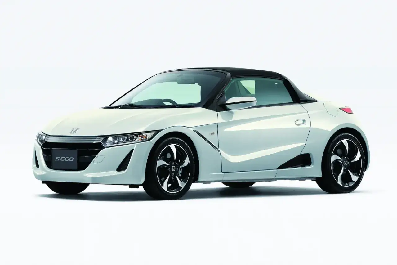 Biały roadster Honda S660 z czarnym dachem, sportowymi felgami i agresywnym przodem.
