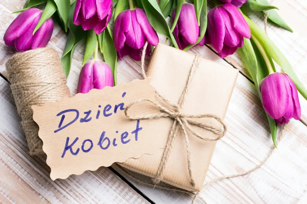 Piękny prezent na Dzień Kobiet: bukiet fioletowych tulipanów, zawinięty w papier prezentowy i ozdobiony sznurkiem.