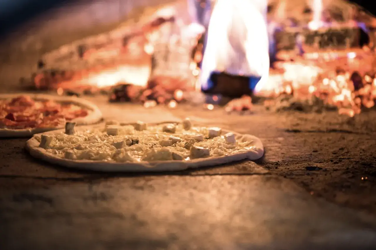 pieczenie pizz w ceglanym piecu opalanym drewnem