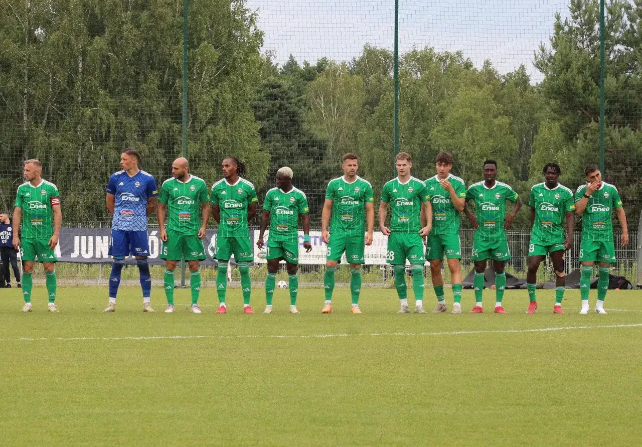 Radomiak Radom zawodnicy w zielonych strojach stoją w szeregu na boisku.
