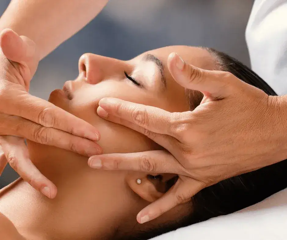 Masaż Kobido twarzy w spa, zbliżenie na dłonie terapeuty